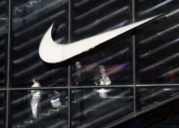 People descend stairs inside a Nike store in New York