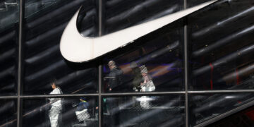 People descend stairs inside a Nike store in New York