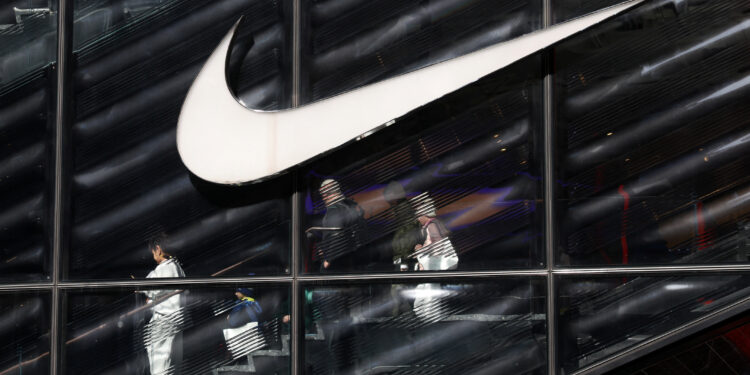 People descend stairs inside a Nike store in New York
