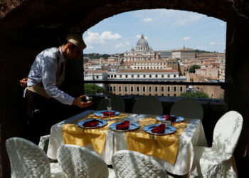 A waiter prepares a table for customers in a bar inside Castel Sant'Angelo in Rome