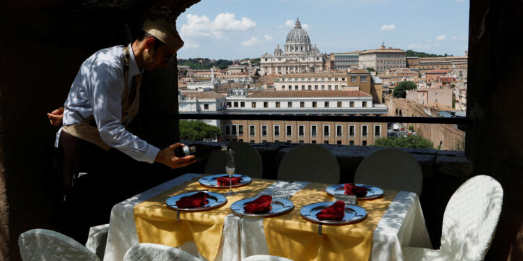 A waiter prepares a table for customers in a bar inside Castel Sant'Angelo in Rome
