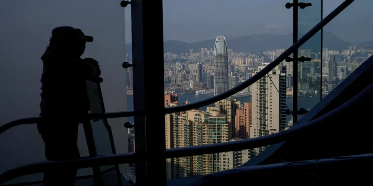Tourists view Hong Kong's skyline from The Peak, with Two International Finance Centre (IFC II) in Central in the background, in Hong Kong, China, February 24, 2025. REUTERS/Tyrone Siu/File Photo